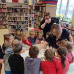 Dzieci pod opieką bibliotekarek wykonują zadania.