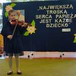 Absolwentka przedszkola gra na skrzypcach.
