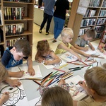 Dzieci wykonują zadanie w bibliotece.