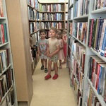 Dzieci idą alejką w bibliotece.