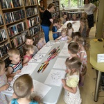 Dzieci wykonują zadanie w bibliotece.