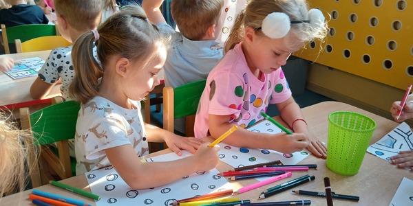 Dwie dziewczynki kolorują karty pracy z kropkami.