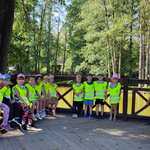 Grupowe zdjęcie dzieci nad stawem na wycieczce w parku.