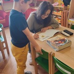Autorka wpisuje dedykację do książki dla chłopca.