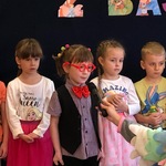 Dziewczynka w przebraniu Pana Hilarego mówi wiersz do mikrofonu.