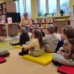 Dzieci z grupy V słuchają opowiadania czytanego przez panią bibliotekarkę.