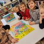 Dzieci pozują do zdjęcia z ułożonymi puzzlami z wizerunkiem Polski.