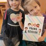 Dwie dziewczynki trzymają kartę obrazkową z prawami dziecka - gr. II Misie.