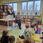 Dzieci z grupy IV słuchają opowiadania czytanego przez panią bibliotekarkę.