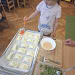 Dziewczynka smaruje pędzelkiem kuchennym Spankakopite.