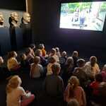 Dzieci oglądają film edukacyjny w Muzeum rzeźby.