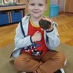 Chłopiec pokazuje do zdjęcia eksponat przyrodniczy - grzybnię.