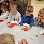 Dzieci wykonują pracę plastyczną - Mikołaja.