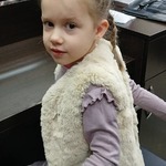 Dziewczynka na stanowisku fryzjerskim w pięknej fryzurze.