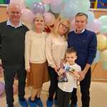 Chłopiec z dziadkami na ściance z balonów.