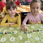 Dziewczynki pokazują wykonane planety z plasteliny.