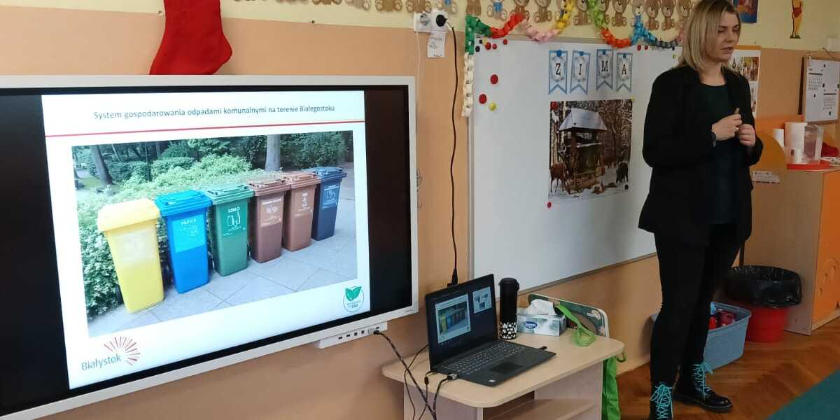 Dzieci oglądają prezentację związaną z segregacją odpadów.