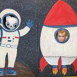 Dziewczynka wraz z Kicią Kocią pozuje do zdjęcia w fotościance z astronautą i rakietą.