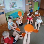 Dzieci wykonują ćwiczenia z frisbee. 