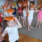 Dzieci wykonują ćwiczenia z frisbee. 