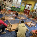 Dzieci wraz z rodzicami malują farbami na folii.