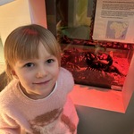 Dziewczynka stoi przy terrarium z karaczanami.