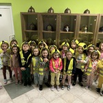 Grupowe zdjęcie Smerfów w kaskach i kamizelkach podczas zajęć edukacyjnych w Państwowej Straży Pożarnej.
