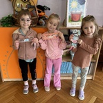 Trzy dziewczynki prezentują swoje zakładki do książki.