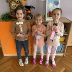 Trzy dziewczynki prezentują swoje zakładki do książki.