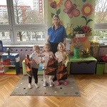 Trzy dziewczynki pozują do zdjęcia z nauczycielką po odebraniu nagród.