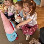 Dziewczynka bada stetoskopem swoją maskotkę.