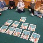 Dzieci patrzą na plansze edukacyjne związane z myciem rąk.