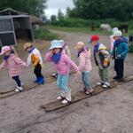 Dzieci jadą na drewnianych nartach