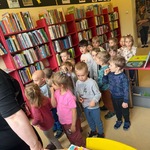 Dzieci stoją przy półkach z książkami