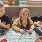 Dziewczynka trzyma kabanosy w buzi, zrobiła z nich kły.
