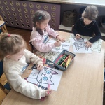 Dziewczynki kolorują obrazek z kotem.