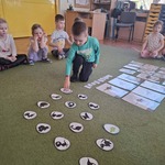 Chłopiec rozwiązuje memory. Szuka dinozaura do pary. 