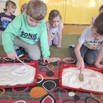 Chłopcy wcielają się w archeologów. W piasku poszukują śladów dinozaurów. 