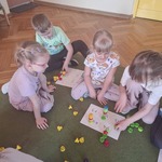 Dzieci wykonują obliczenia matematyczne w zakresie odejmowania i dodawania. Używają w obliczeniach kolorowych zakrętek. 