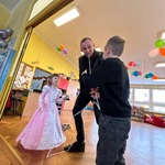 Dwójka dzieci wykonuje sztuczkę z magikiem.