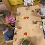 Dzieci wycinają liście z kolorowych papilotek.
